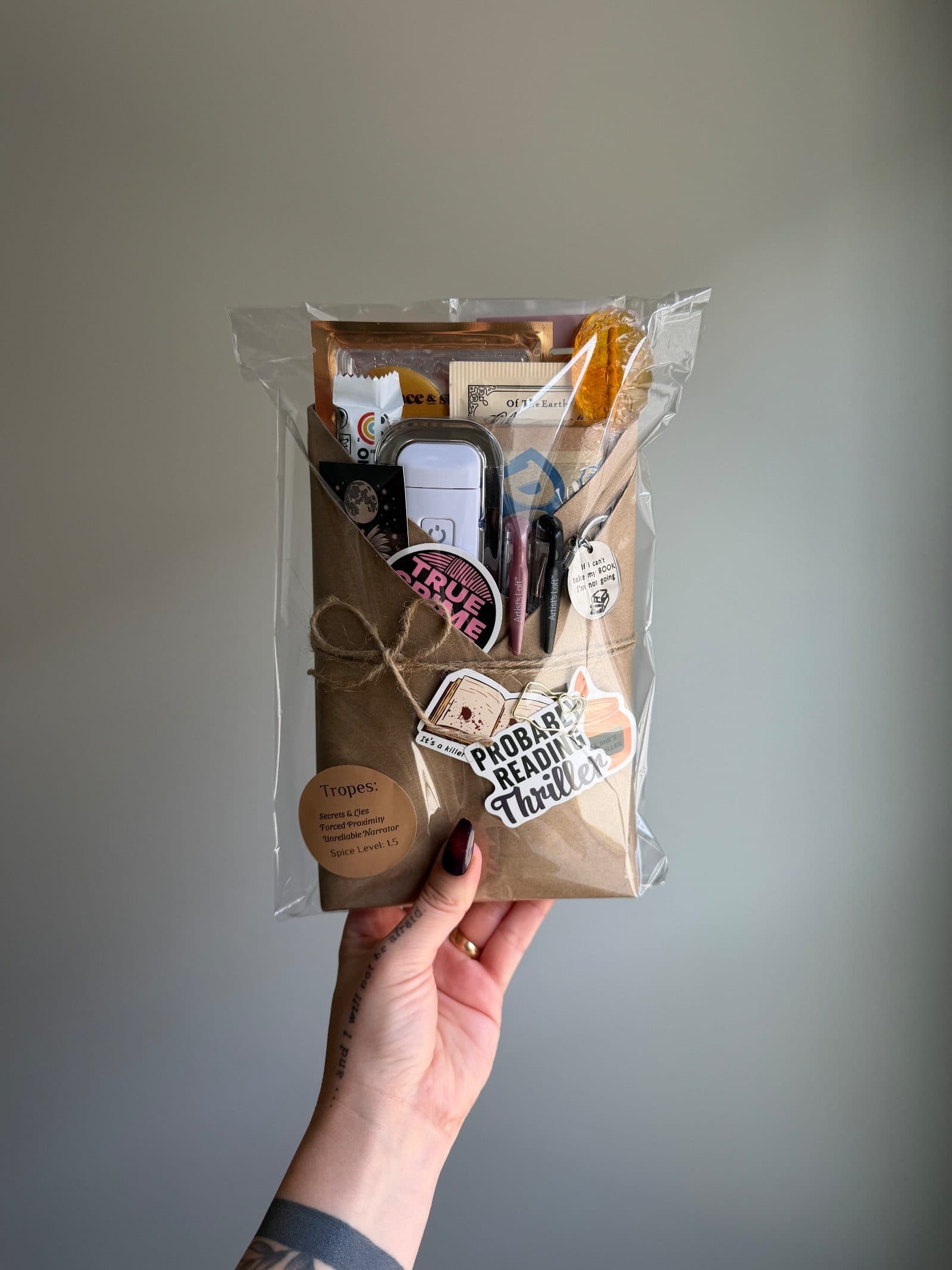 A row of books wrapped in floral kraft paper standing against a bookend, beside a tied stack of plain kraft parcels